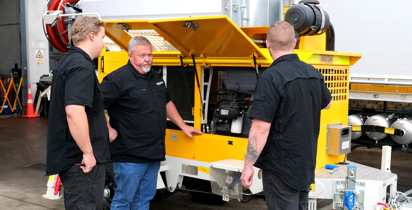 The PS Equipment team in front of a Jacon concrete trailer pump